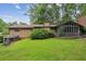 Lush backyard with mature trees and greenery, featuring a brick home and screened porch at 2700 Regency E Dr, Tucker, GA 30084