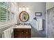 Bathroom featuring decorative mirror and vanity with sink and window with white shutters at 2700 Regency E Dr, Tucker, GA 30084
