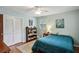 Bedroom with hardwood floors, blue accent wall, ceiling fan and two windows with white shutters at 2700 Regency E Dr, Tucker, GA 30084