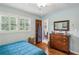 Bedroom features hardwood floors, wood dresser, ceiling fan and two windows with white shutters at 2700 Regency E Dr, Tucker, GA 30084