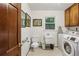 Functional laundry room with modern washer and dryer, toilet, and ample counter space at 2700 Regency E Dr, Tucker, GA 30084
