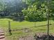 View of a spacious backyard featuring a chain link fence and mature trees offering ample space and shade for outdoor activities at 2875 Carriage Ln, Atlanta, GA 30349