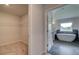 Bathroom view showing a soaking tub next to a walk-in closet with wire shelving at 68 Homesite Cooper W Cv, Fayetteville, GA 30214