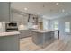 Modern kitchen features a large island, stainless steel appliances, and stylish gray cabinetry at 68 Homesite Cooper W Cv, Fayetteville, GA 30214