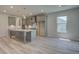 This is a beautiful kitchen with an island, gray cabinets, and wood-look flooring at 68 Homesite Cooper W Cv, Fayetteville, GA 30214