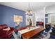 Formal dining room with blue accent wall, plush blue carpet, and an elegant chandelier at 1421 Peachtree Ne St # 214, Atlanta, GA 30309