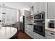 Elegant kitchen showcasing white cabinets, marble countertops, stainless appliances, and brick flooring at 1421 Peachtree Ne St # 214, Atlanta, GA 30309