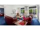 Bright living room with plush blue carpeting, red sofas, and large windows with shutter-style shades at 1421 Peachtree Ne St # 214, Atlanta, GA 30309