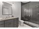 Bathroom featuring gray vanity, dark framed mirror, glass shower, hanging pendant lights, and tiled flooring at 110 3Rd St, Fayetteville, GA 30214