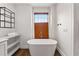 Bright bathroom features a soaking tub under a window and modern fixtures at 110 3Rd St, Fayetteville, GA 30214