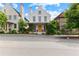Inviting three-story home featuring a prominent chimney, well-placed windows, and a cozy, plant-covered front porch at 110 3Rd St, Fayetteville, GA 30214