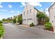 Exterior shot showcasing a white stucco home with attached garages, complementing trees, and a well-paved street at 110 3Rd St, Fayetteville, GA 30214