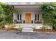 Welcoming front porch adorned with climbing plants, comfortable seating, and a stylish entrance with a natural wood door at 110 3Rd St, Fayetteville, GA 30214