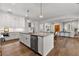 Open-concept kitchen boasts white cabinets, hardwood floors and stainless steel appliances at 110 3Rd St, Fayetteville, GA 30214
