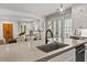 Modern kitchen island featuring a concrete countertop and a black faucet with views to the living room and french doors at 110 3Rd St, Fayetteville, GA 30214