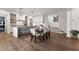 Open kitchen with a center island, stainless appliances, and wood flooring flowing into the dining area at 110 3Rd St, Fayetteville, GA 30214