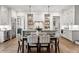 Open kitchen and dining area with stainless steel appliances, wood floors, and stylish pendant lighting at 110 3Rd St, Fayetteville, GA 30214