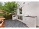 Backyard patio featuring gravel, string lights, wood chairs and table, and a built-in outdoor grill at 110 3Rd St, Fayetteville, GA 30214