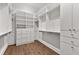 Bright walk-in closet featuring custom white shelving, drawers, and hardwood floors, offering ample storage at 110 3Rd St, Fayetteville, GA 30214