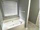Bathroom featuring a soaking tub with marble-look surround, complemented by fixtures, creating a cozy, functional design at 1255 Summit Point Ln, Snellville, GA 30078