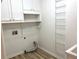 Well-lit laundry room with shelving, washer hookups, and wooden flooring, adding convenience and style at 1255 Summit Point Ln, Snellville, GA 30078