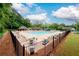 Community pool with seating, lounge chairs and fence surrounded by mature trees at 2759 Beddington Way, Suwanee, GA 30024