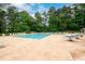 A view of the community pool with lounge chairs, tables, and mature trees surrounding the area at 2759 Beddington Way, Suwanee, GA 30024