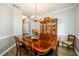 Dining room features a wooden table, chandelier, hardwood flooring, and wall decor at 2759 Beddington Way, Suwanee, GA 30024