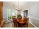 Elegant dining room featuring a wood table, chandelier, and large window at 2759 Beddington Way, Suwanee, GA 30024