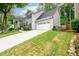 Beautiful two-story home with a white garage door, manicured lawn, and stone accents at 2759 Beddington Way, Suwanee, GA 30024