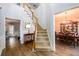 Inviting foyer with wood flooring, a staircase with carpeted steps, and views into the dining room at 2759 Beddington Way, Suwanee, GA 30024