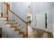 Bright foyer with wood floors, a staircase with wood and white accents, and natural light from the front door at 2759 Beddington Way, Suwanee, GA 30024