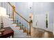 Bright foyer with hardwood floors, a staircase with carpet runner, and a view into other rooms at 2759 Beddington Way, Suwanee, GA 30024