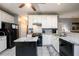 Well-lit kitchen featuring white cabinets, granite countertops, and a functional kitchen island at 2759 Beddington Way, Suwanee, GA 30024