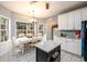 Bright breakfast nook with large windows and a kitchen island, adjacent to white kitchen cabinets at 2759 Beddington Way, Suwanee, GA 30024