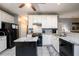 Well-lit kitchen features granite countertops, white cabinets and black appliances at 2759 Beddington Way, Suwanee, GA 30024