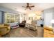 Open living room with a view of a window, kitchen, hardwood floors and ceiling fan at 2759 Beddington Way, Suwanee, GA 30024