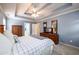 Spacious main bedroom features tray ceilings, dresser with TV, and ensuite access at 2759 Beddington Way, Suwanee, GA 30024