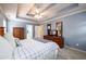 Comfortable bedroom with tray ceilings, dresser, and TV at 2759 Beddington Way, Suwanee, GA 30024