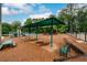 A view of the community playground with swings, slides, picnic tables, and surrounding trees at 2759 Beddington Way, Suwanee, GA 30024