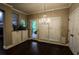 Dining area with chandelier lighting, hardwood floors, glass door to deck, and white window blinds at 308 Forkwood Trl, Woodstock, GA 30189