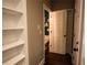 Hallway with hardwood floors, shelving, and view of half bathroom at 308 Forkwood Trl, Woodstock, GA 30189