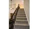 Carpeted staircase with decorative wrought iron spindles and wood handrail at 308 Forkwood Trl, Woodstock, GA 30189