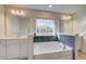 Bright bathroom featuring a tub, dual vanities and white cabinets at 327 Tulip Dr, Covington, GA 30016