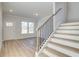 Entryway featuring hardwood floors, a staircase with iron balusters, and an open view to a sunlit room at 327 Tulip Dr, Covington, GA 30016