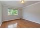 Serene bedroom with hardwood floors, neutral walls, and a view of greenery from the window at 100 Biscayne Nw Dr # D7, Atlanta, GA 30309