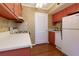Bright kitchen with classic appliances, featuring red cabinets and a white refrigerator and countertops at 100 Biscayne Nw Dr # D7, Atlanta, GA 30309