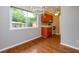 Open floorplan with hardwood floors, chandelier, large window, neutral wall color, and view of kitchen at 100 Biscayne Nw Dr # D7, Atlanta, GA 30309