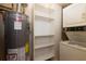 Functional laundry area features a water heater, shelving, and a stacked washer and dryer at 100 Biscayne Nw Dr # D7, Atlanta, GA 30309