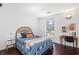 Bedroom with hardwood floors, large window, and a straw hat on the bed at 1127 Riverbend Club Se Dr, Atlanta, GA 30339